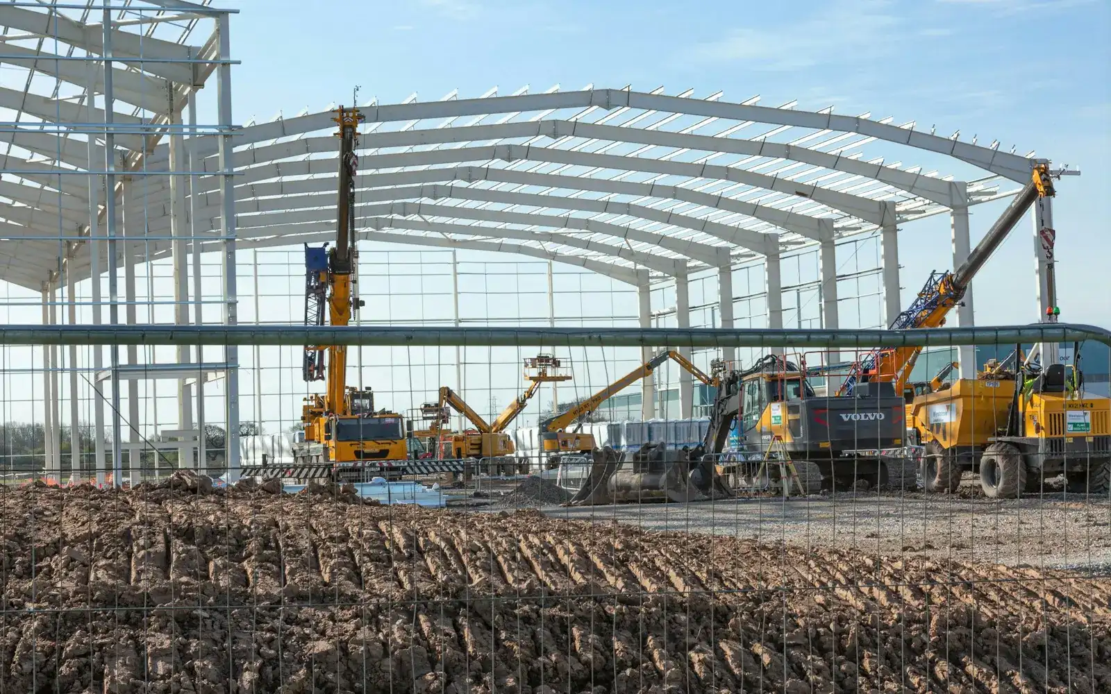 Steel portal frames rising on an industrial construction site